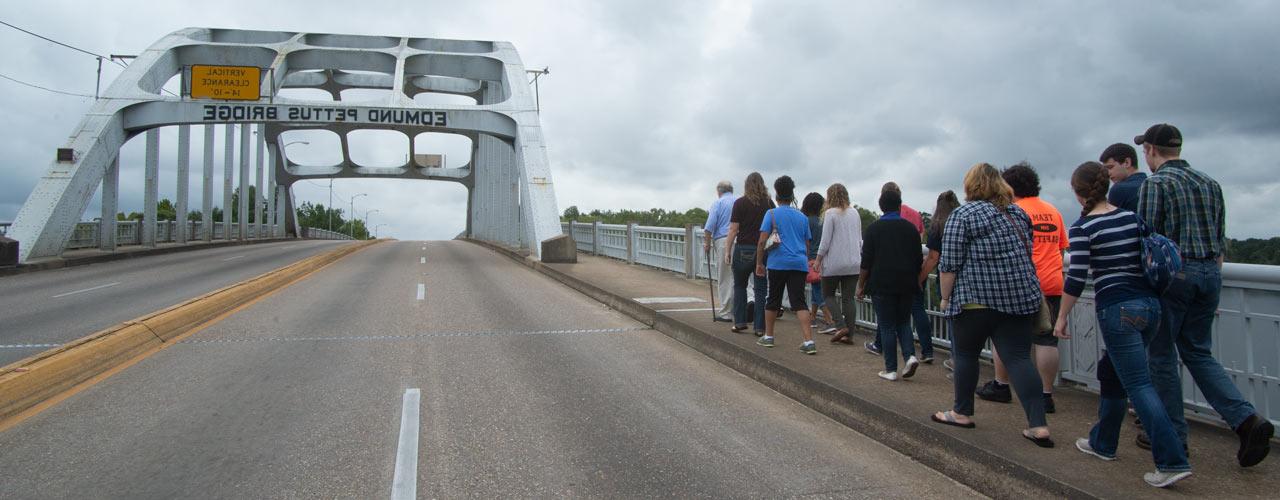 Civil Rights Bus Tour students and faculty walking up the Edmund Pettus Bridge