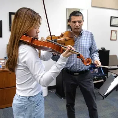 Professor and college student playing violins